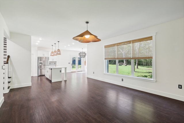 unfurnished living room featuring a chandelier and dark hardwood / wood-style flooring