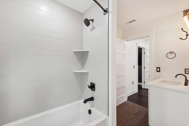 bathroom featuring tiled shower / bath, vanity, and wood-type flooring