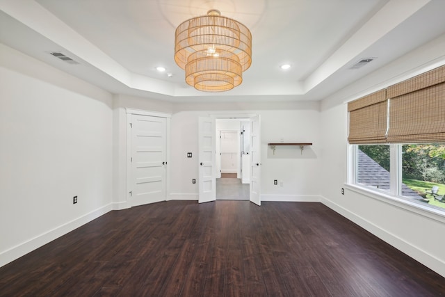 unfurnished living room with a raised ceiling and dark hardwood / wood-style floors