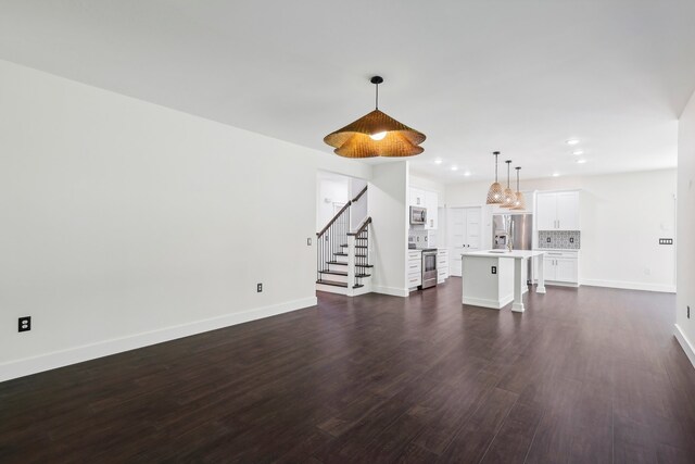 unfurnished living room featuring sink and dark wood-type flooring