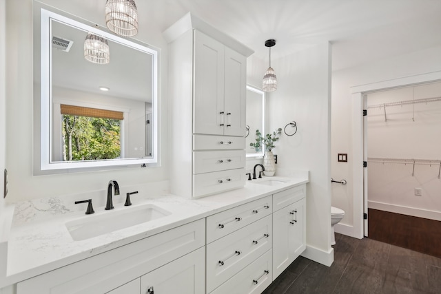 bathroom with vanity, hardwood / wood-style floors, toilet, and a chandelier