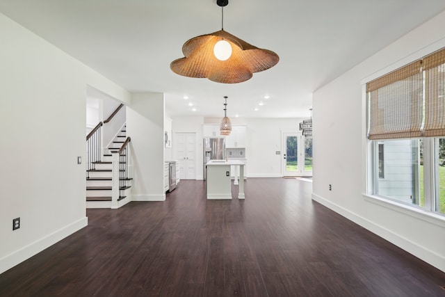 unfurnished living room featuring dark wood-type flooring and plenty of natural light