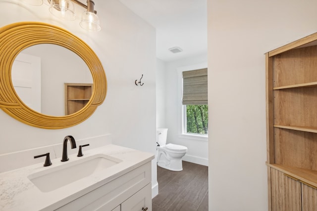 bathroom with vanity, toilet, and hardwood / wood-style flooring