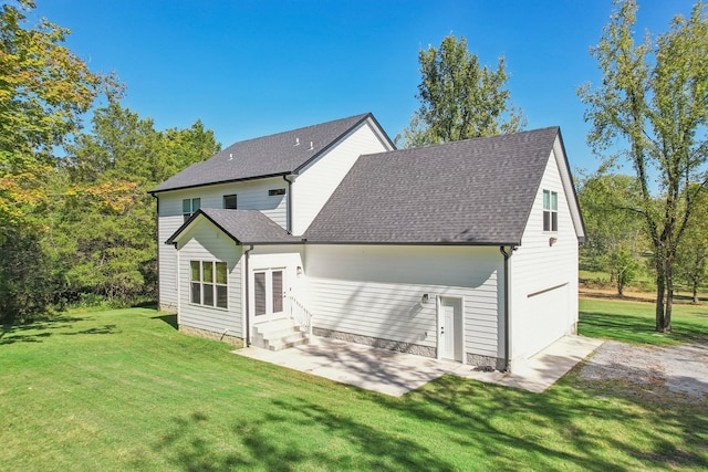 rear view of house with a garage and a yard