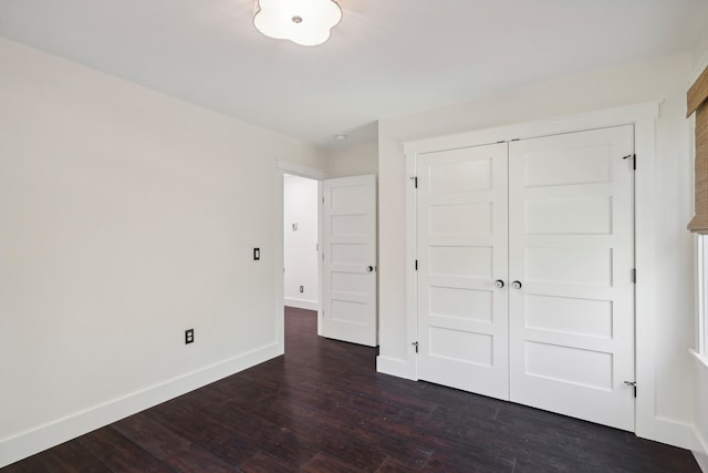 unfurnished bedroom with a closet and dark hardwood / wood-style floors