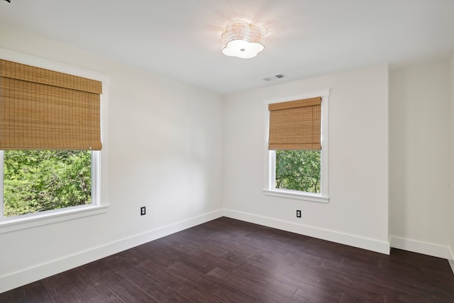 unfurnished room with dark hardwood / wood-style flooring