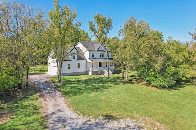 view of front of house featuring a garage, a front lawn, and a porch