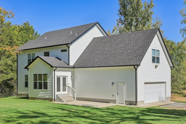 back of house with a yard and a garage