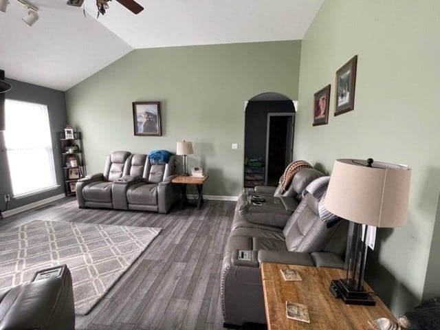 living room with wood-type flooring, vaulted ceiling, and ceiling fan