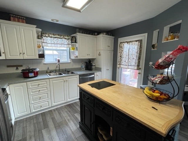 kitchen featuring dark hardwood / wood-style flooring, tasteful backsplash, stainless steel appliances, sink, and white cabinetry