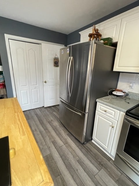 kitchen featuring dark hardwood / wood-style floors, white cabinetry, backsplash, and appliances with stainless steel finishes