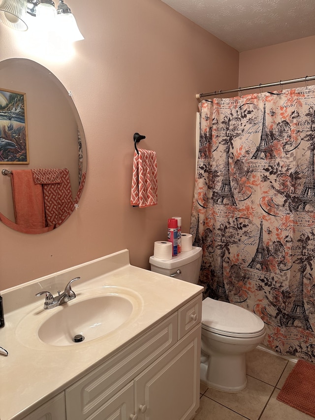 bathroom featuring tile patterned floors, vanity, toilet, and a textured ceiling