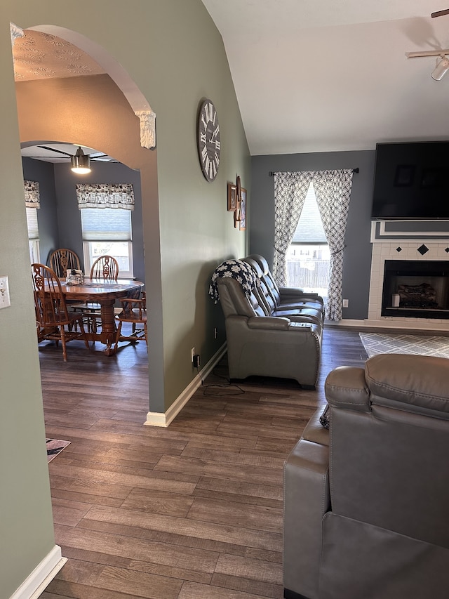 living room featuring dark hardwood / wood-style floors, vaulted ceiling, plenty of natural light, and ceiling fan