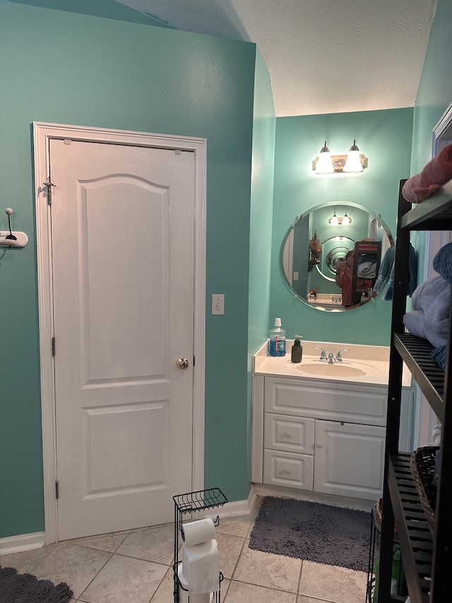 bathroom featuring tile patterned floors, vanity, and a textured ceiling