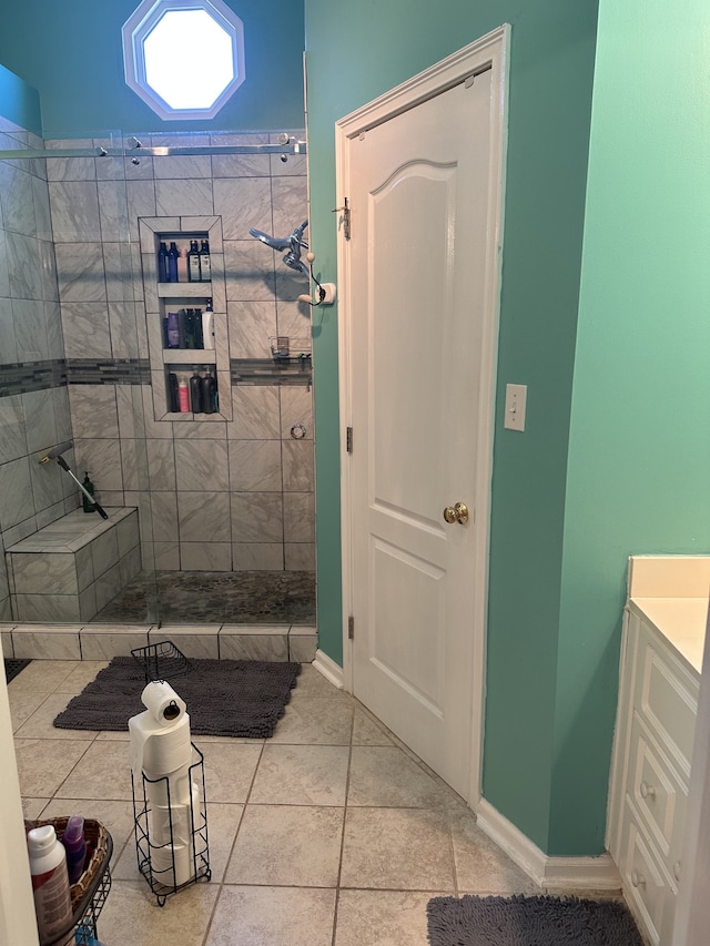 bathroom featuring tiled shower, vanity, and tile patterned floors