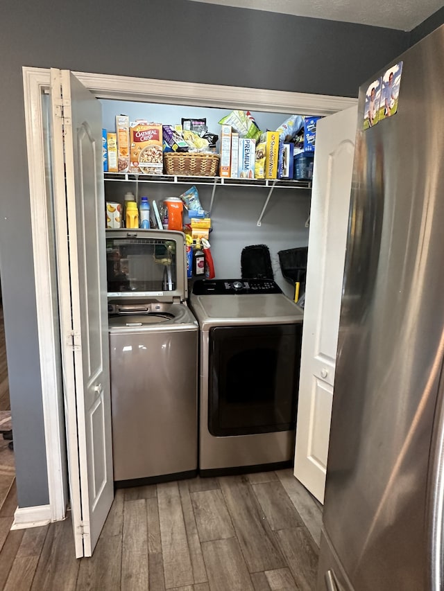 laundry area with dark hardwood / wood-style flooring and washer and clothes dryer