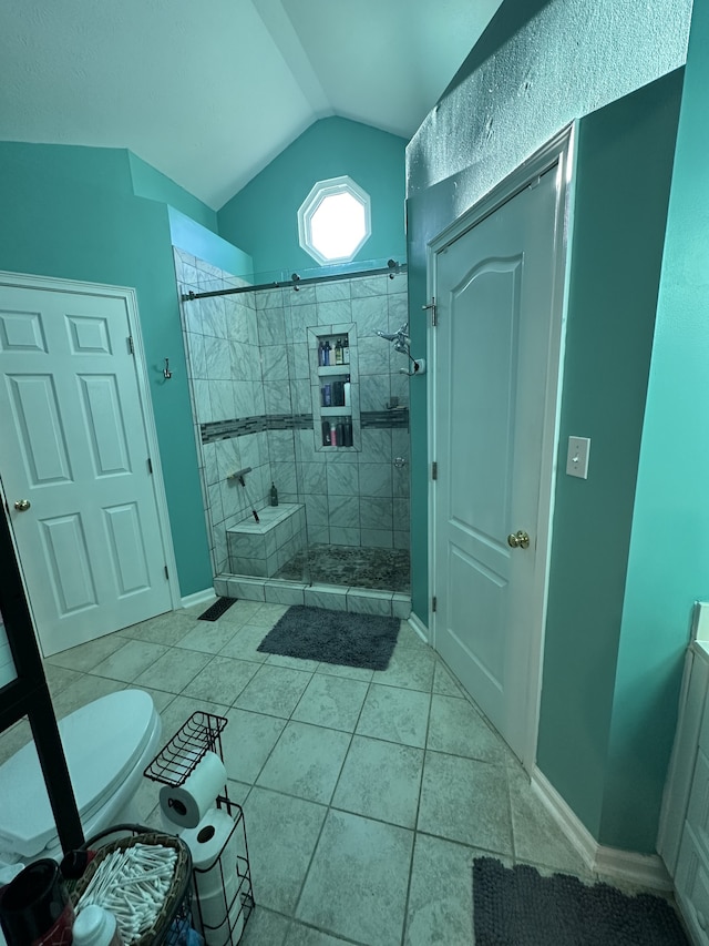 bathroom with tiled shower, tile patterned floors, and vaulted ceiling