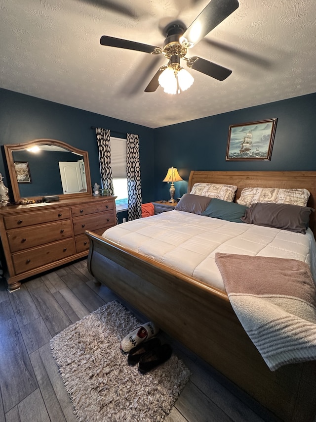 bedroom featuring wood-type flooring, a textured ceiling, and ceiling fan