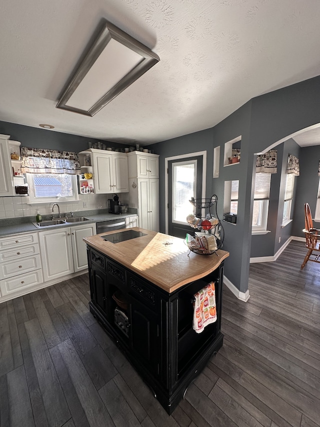 kitchen with decorative backsplash, a textured ceiling, sink, dark hardwood / wood-style floors, and white cabinetry