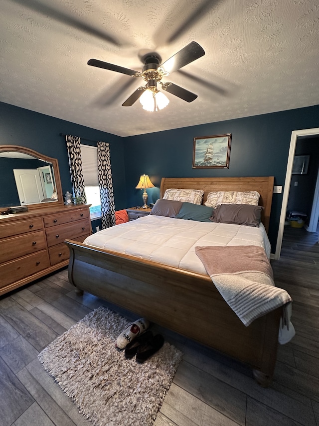 bedroom with a textured ceiling, hardwood / wood-style flooring, and ceiling fan