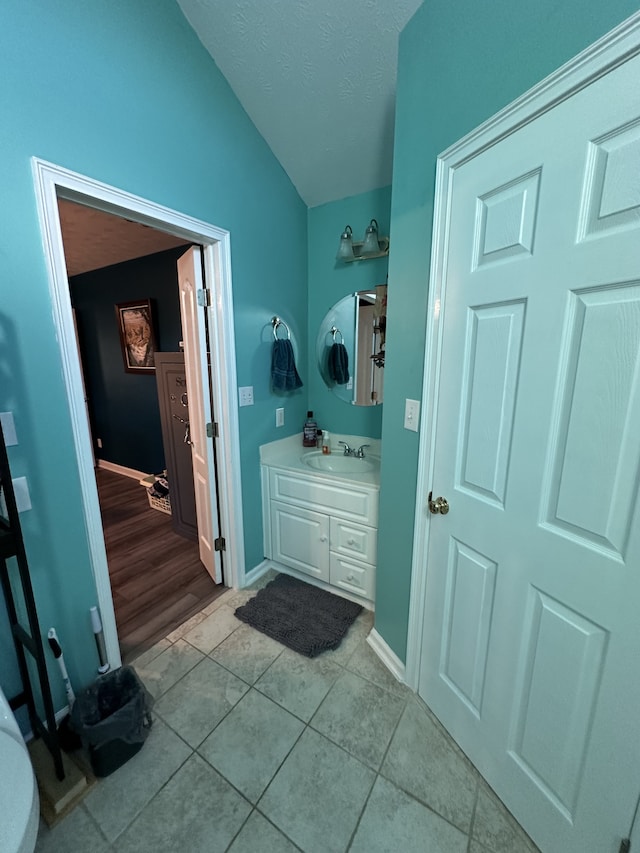 bathroom with wood-type flooring, vanity, and vaulted ceiling