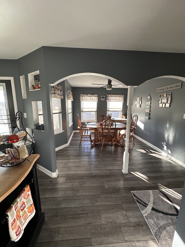 dining room with ornate columns, ceiling fan, and dark hardwood / wood-style floors