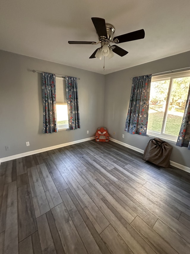 spare room featuring hardwood / wood-style floors, a wealth of natural light, and ceiling fan