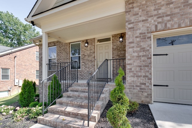 view of exterior entry with a garage and a porch