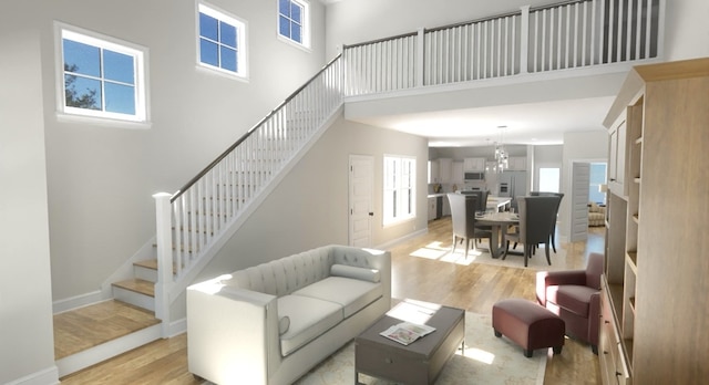 living room featuring light hardwood / wood-style floors, a high ceiling, and a chandelier