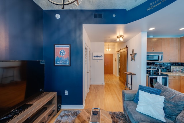 living room featuring light hardwood / wood-style floors and a barn door