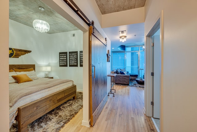 bedroom featuring a barn door and light wood-type flooring