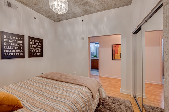 bedroom with a notable chandelier, a closet, and light hardwood / wood-style floors