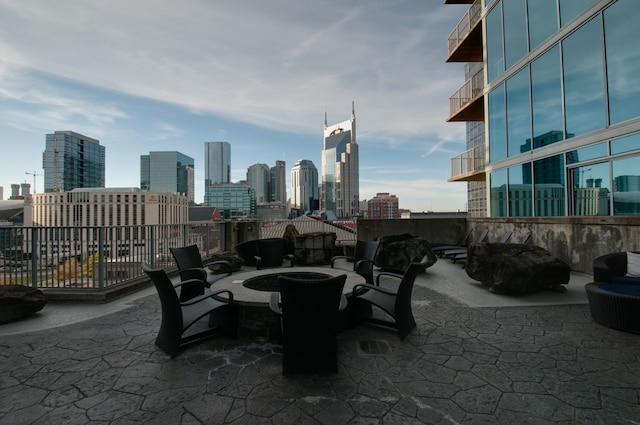 view of patio with a balcony and a fire pit