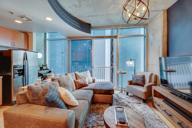 living room with a wall of windows, a notable chandelier, and hardwood / wood-style flooring