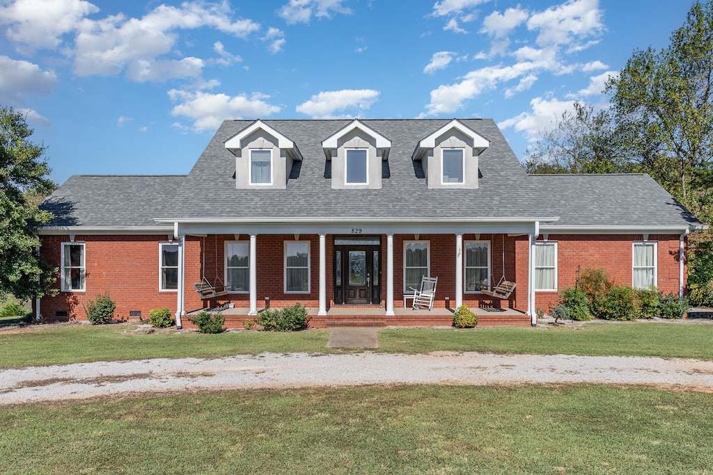 cape cod house featuring a front yard and a porch