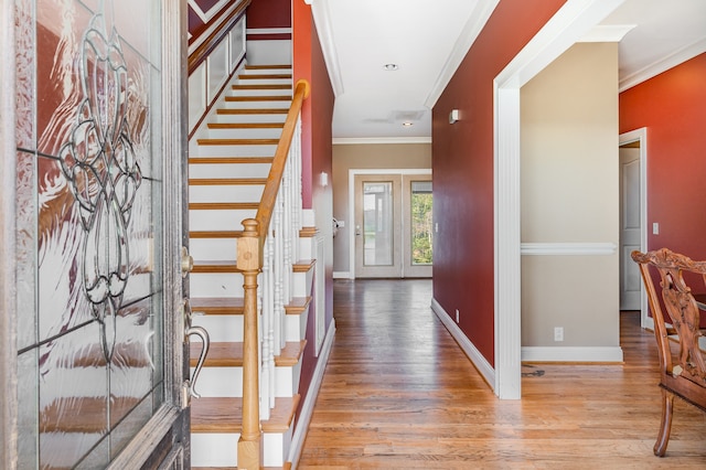 foyer with light wood-type flooring and ornamental molding