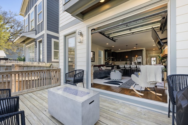 wooden deck featuring an outdoor living space with a fire pit