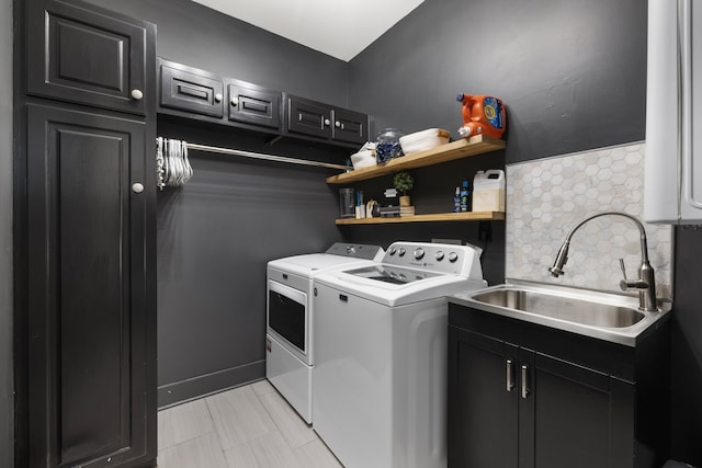 laundry area with washer and clothes dryer, sink, and cabinets