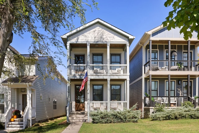 view of front of property featuring a porch, a balcony, and a front lawn