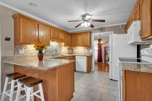 kitchen with white appliances, crown molding, sink, kitchen peninsula, and a textured ceiling