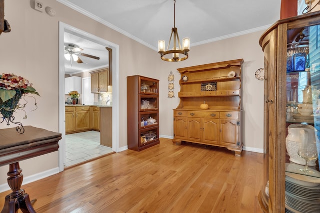 dining room with ornamental molding, ceiling fan with notable chandelier, and light hardwood / wood-style flooring