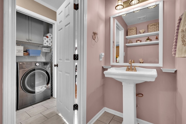 washroom with washer / clothes dryer, cabinets, and light tile patterned floors