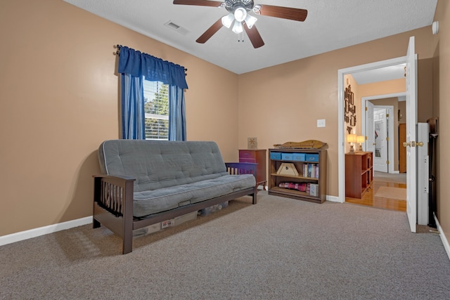 sitting room with ceiling fan and carpet floors