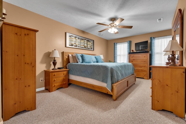 bedroom with light carpet, a textured ceiling, and ceiling fan