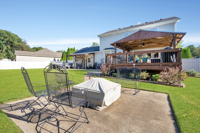 back of property with a wooden deck, a yard, and a patio area