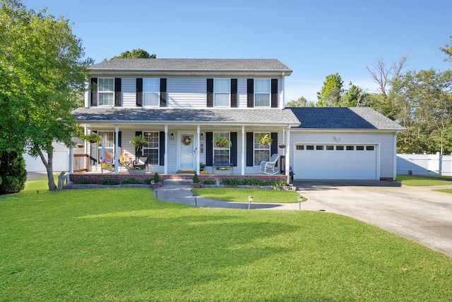 colonial-style house with covered porch, a front yard, and a garage