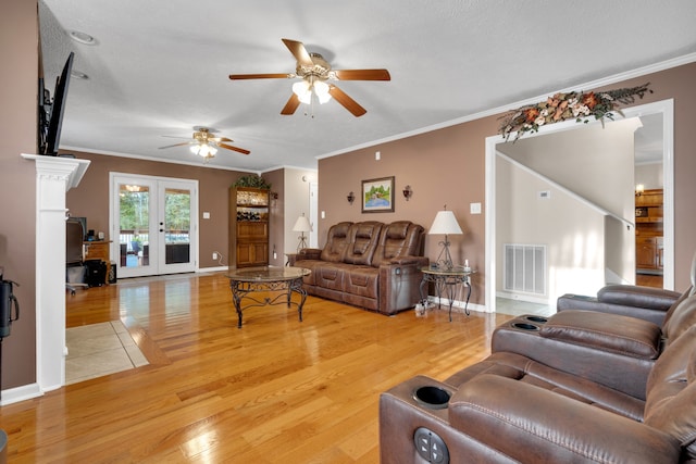 living room featuring wood-type flooring, crown molding, and ceiling fan