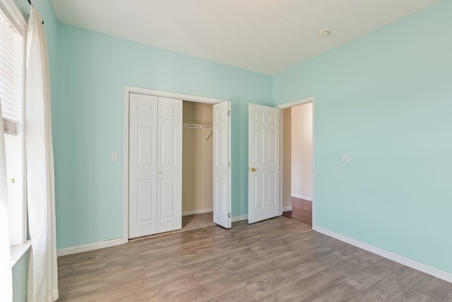 unfurnished bedroom with light hardwood / wood-style flooring and a closet