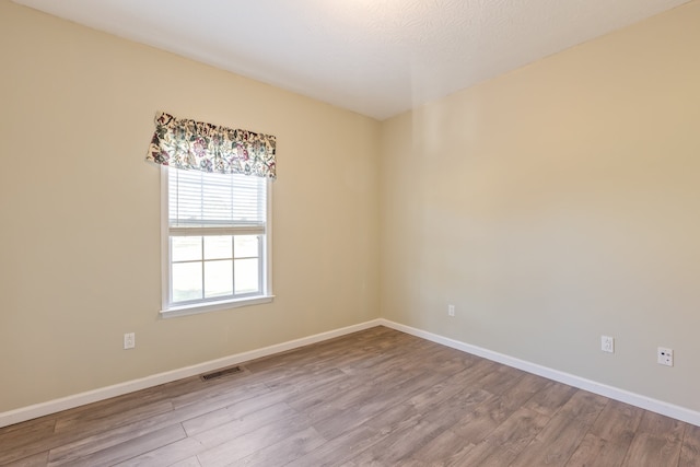 spare room with hardwood / wood-style flooring and a textured ceiling