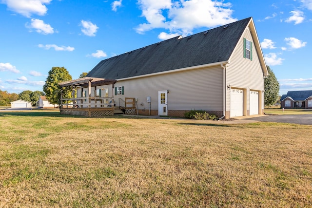 back of house featuring a wooden deck, a garage, and a lawn